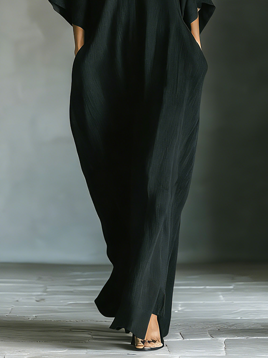 Black maxi dress featuring kimono sleeves and convenient pockets, designed for women in a comfortable oversized cotton blend. 3