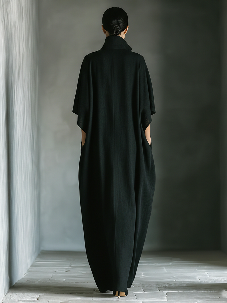 Black maxi dress featuring kimono sleeves and convenient pockets, designed for women in a comfortable oversized cotton blend. 4