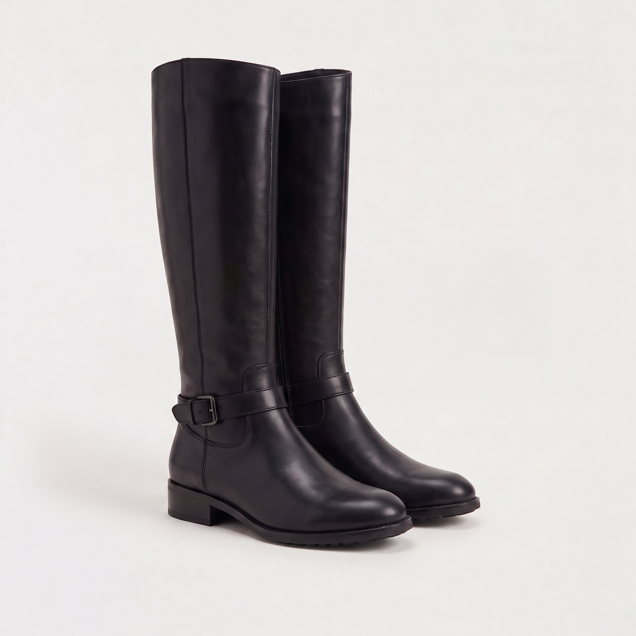 Knee high black riding boots for women with buckled ankle strap, made from faux leather and featuring a low stacked heel. 6