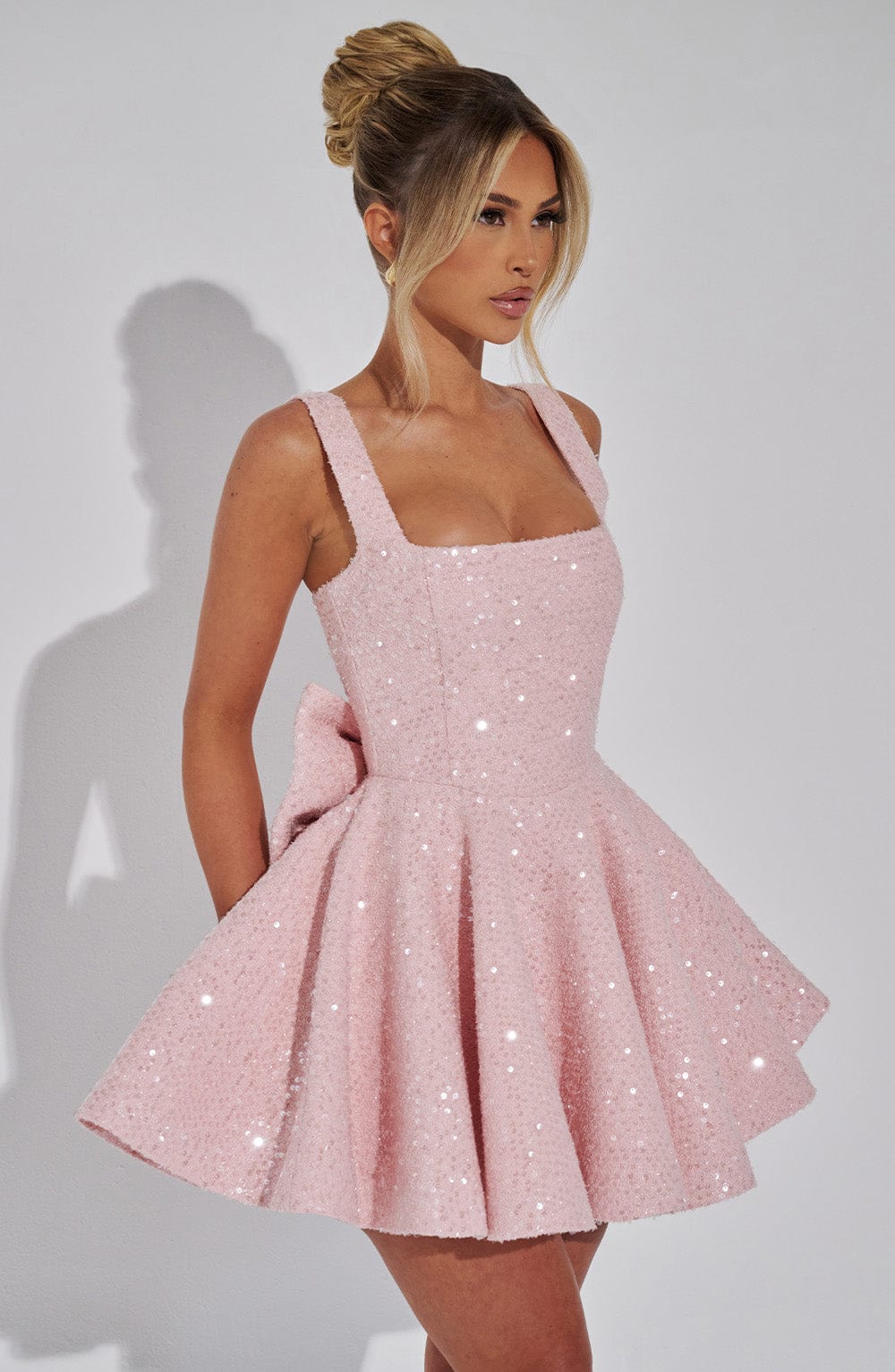 Sequin mini dress with flared skirt and back bow detail, perfect for wedding guests and cocktail parties. 4