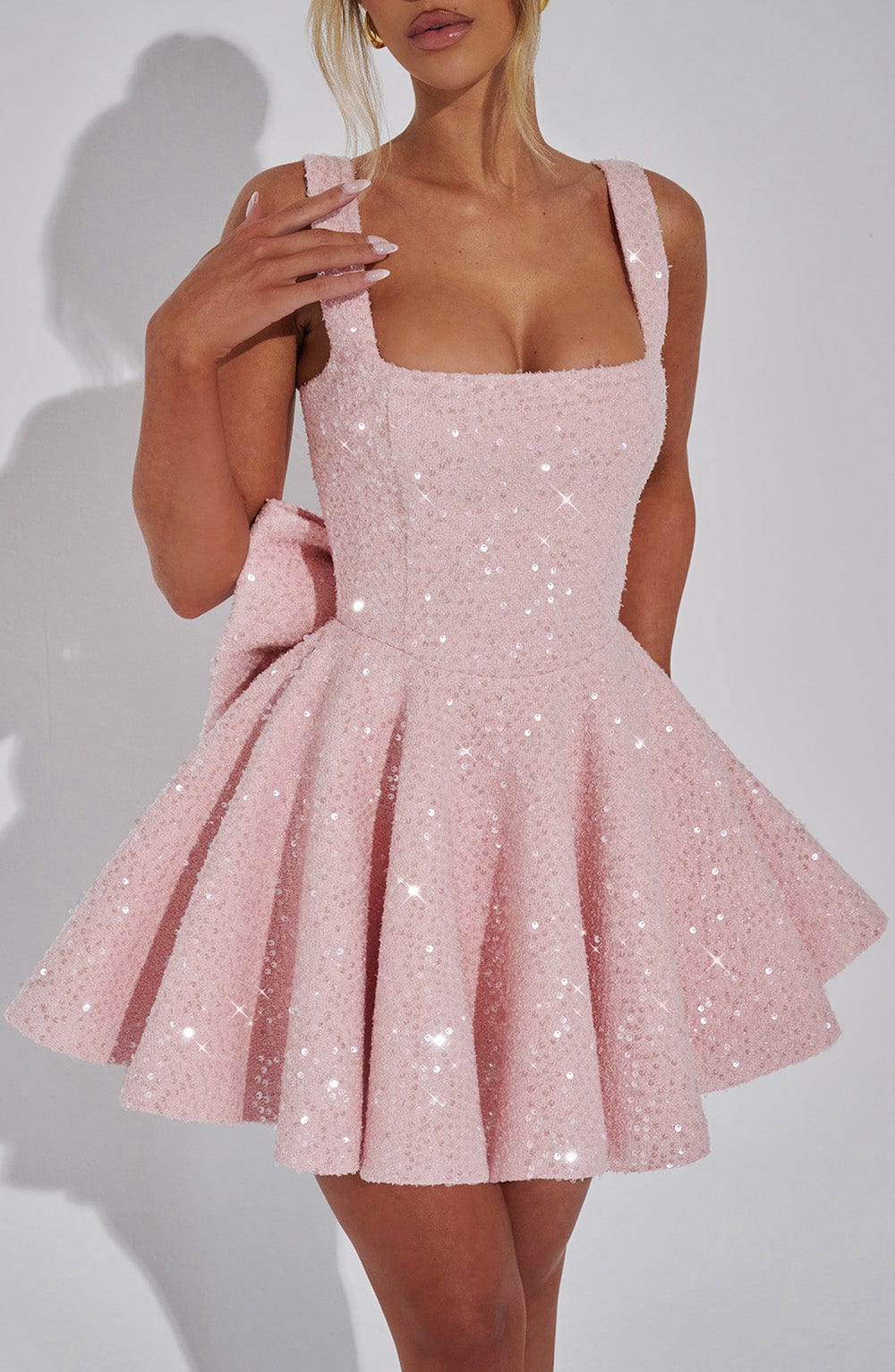 Sequin mini dress with flared skirt and back bow detail, perfect for wedding guests and cocktail parties. 5