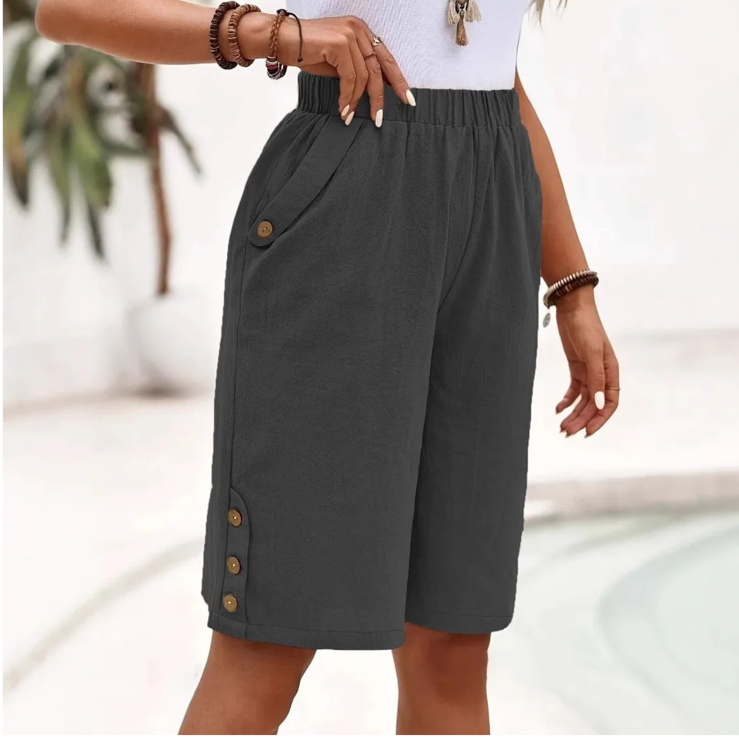Women's Bermuda shorts featuring a high-rise elastic waist and relaxed fit, designed with lightweight fabric and stylish button details for a comfortable and trendy summer look. 4