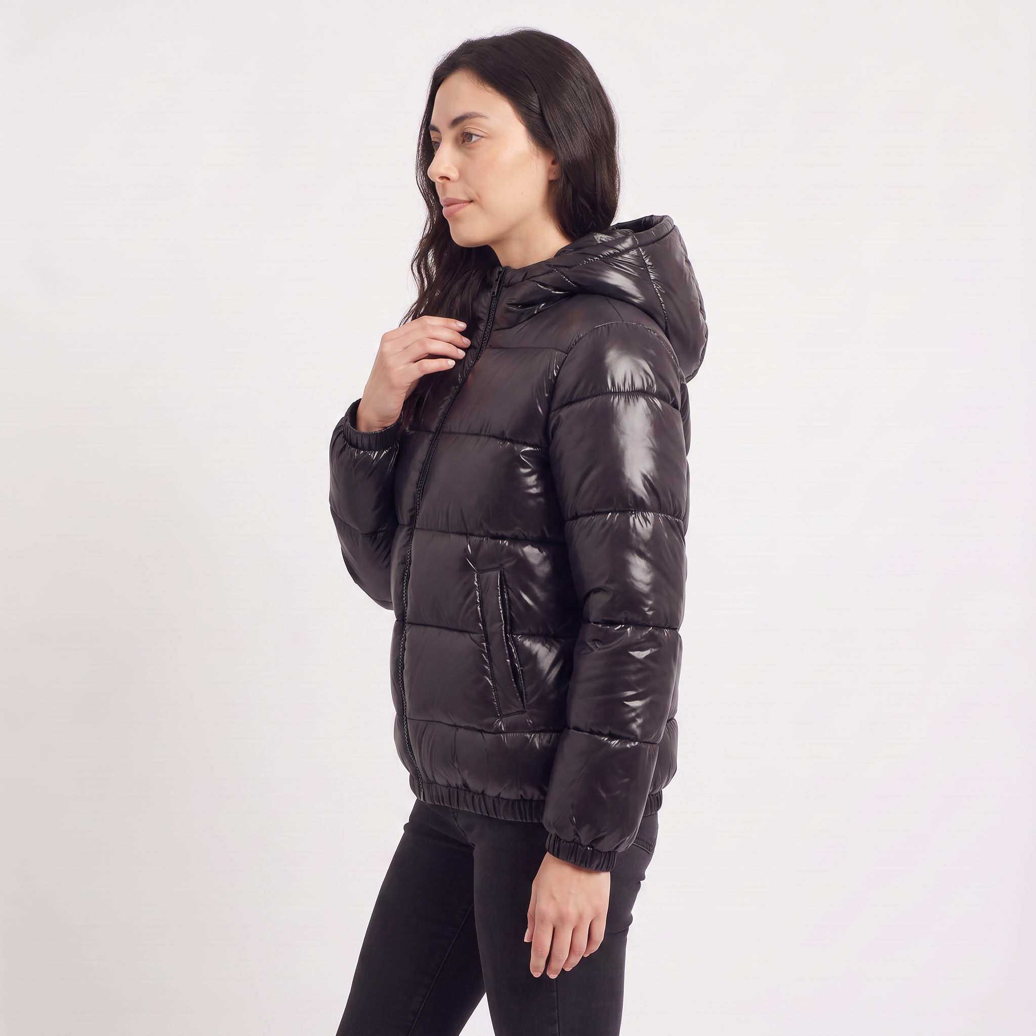 Women's black puffer jacket featuring a stylish attached hood, glossy quilted design, and convenient zip pockets, designed for a relaxed fit perfect for winter wear 4