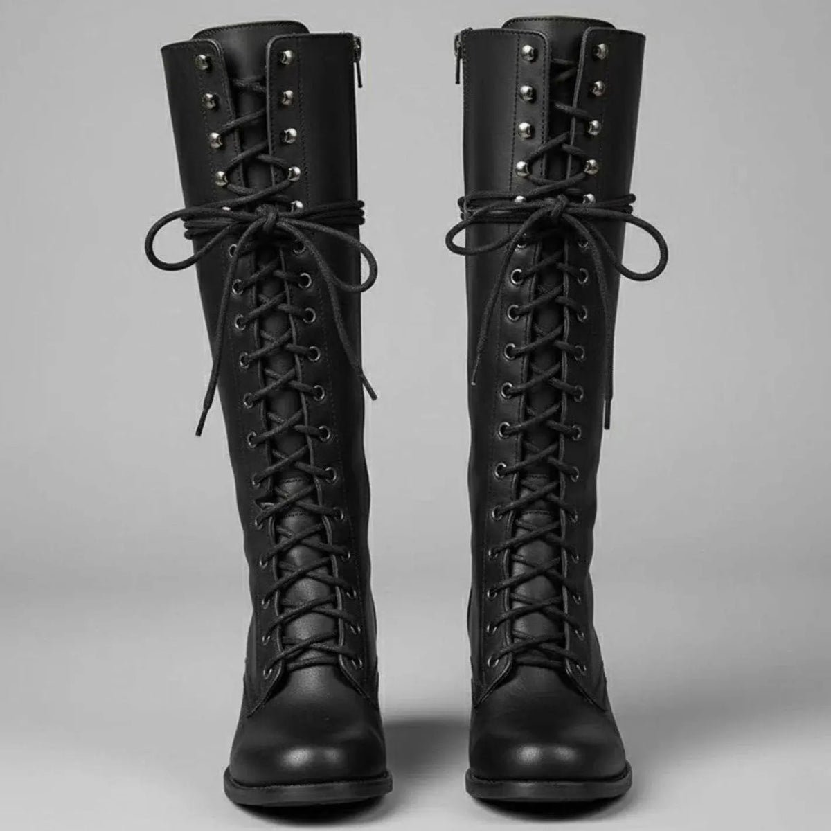 Women's black faux leather knee-high boots featuring a lace-up front, block heel, and stylish stud detail. 0
