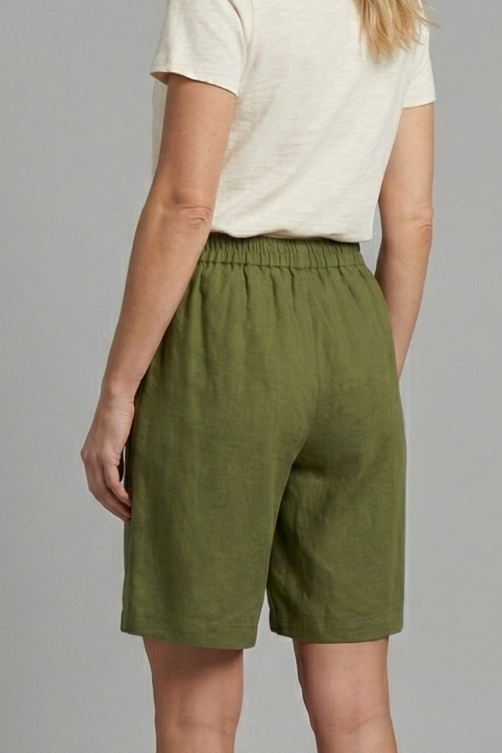 Womens linen shorts featuring an elastic waist and side pockets, designed for a relaxed fit perfect for warm weather. 1