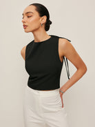 Backless blouse featuring a stylish tie neck detail, sleek sleeveless design, and made from smooth woven fabric, perfect for chic summer outings. 1