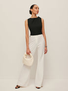 Backless blouse featuring a stylish tie neck detail, sleek sleeveless design, and made from smooth woven fabric, perfect for chic summer outings. 2