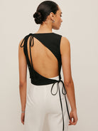 Backless blouse featuring a stylish tie neck detail, sleek sleeveless design, and made from smooth woven fabric, perfect for chic summer outings. 4