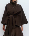 Belted black cape coat with stand collar and button closure, made from wool-style fabric for women, perfect for stylish winter layering. 1