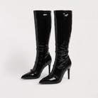 Black knee high boots featuring a sleek patent finish, inner zip closure, and stylish buckled straps, designed with elegant stiletto heels for women. 4