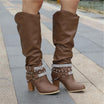 Black knee high boots featuring studded straps and a block heel, crafted from slouchy vegan leather for a stylish and comfortable fit for women. 0