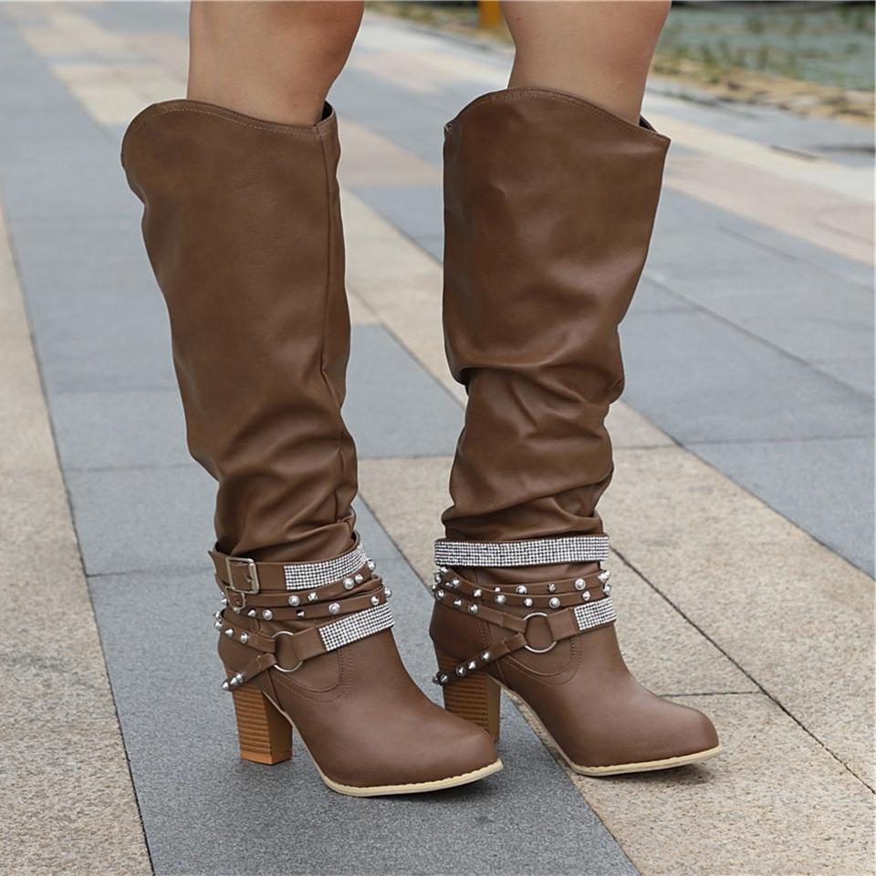 Black knee high boots featuring studded straps and a block heel, crafted from slouchy vegan leather for a stylish and comfortable fit for women. 0