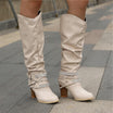 Black knee high boots featuring studded straps and a block heel, crafted from slouchy vegan leather for a stylish and comfortable fit for women. 2