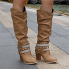 Black knee high boots featuring studded straps and a block heel, crafted from slouchy vegan leather for a stylish and comfortable fit for women. 4