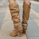 Black knee high boots featuring studded straps and a block heel, crafted from slouchy vegan leather for a stylish and comfortable fit for women. 5