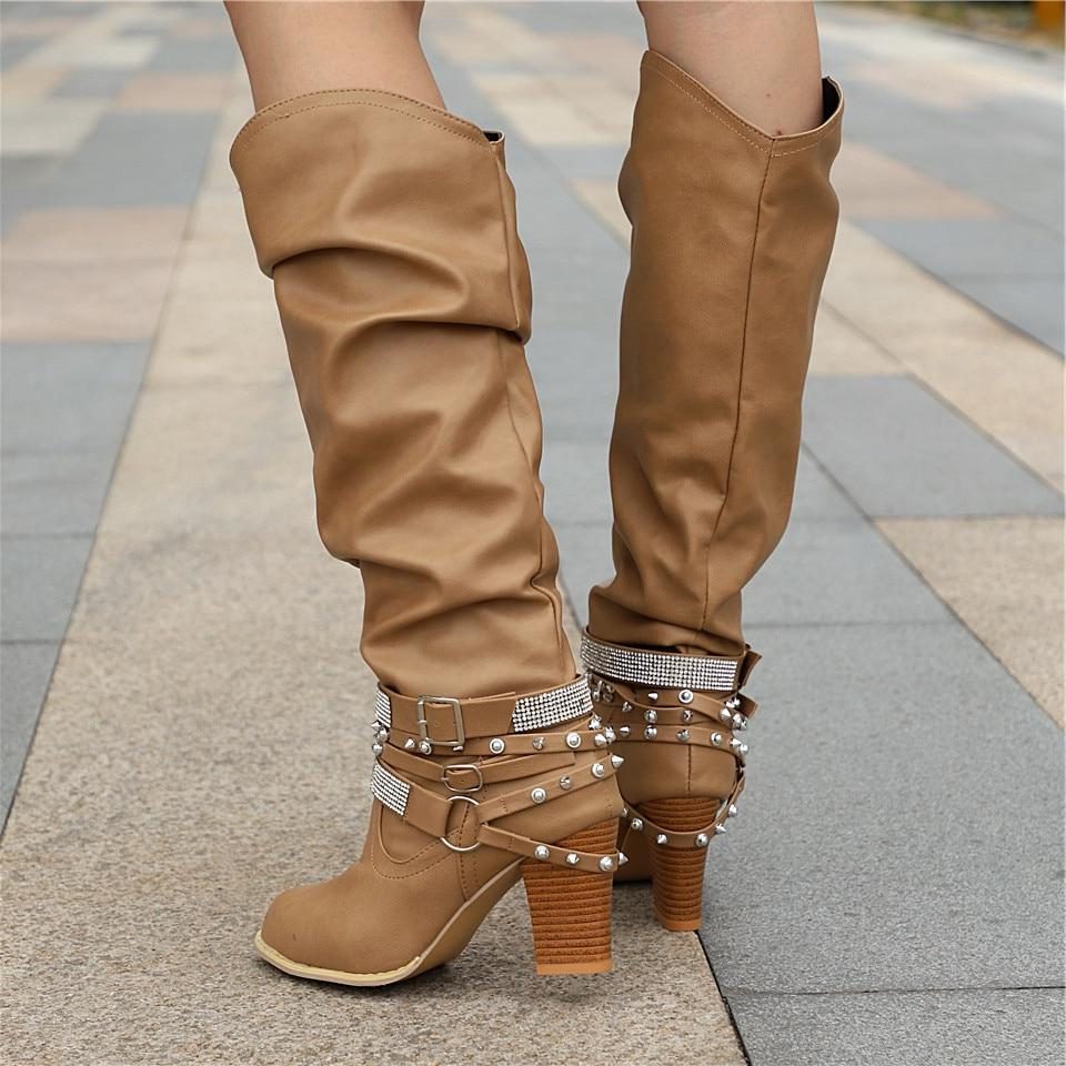 Black knee high boots featuring studded straps and a block heel, crafted from slouchy vegan leather for a stylish and comfortable fit for women. 5