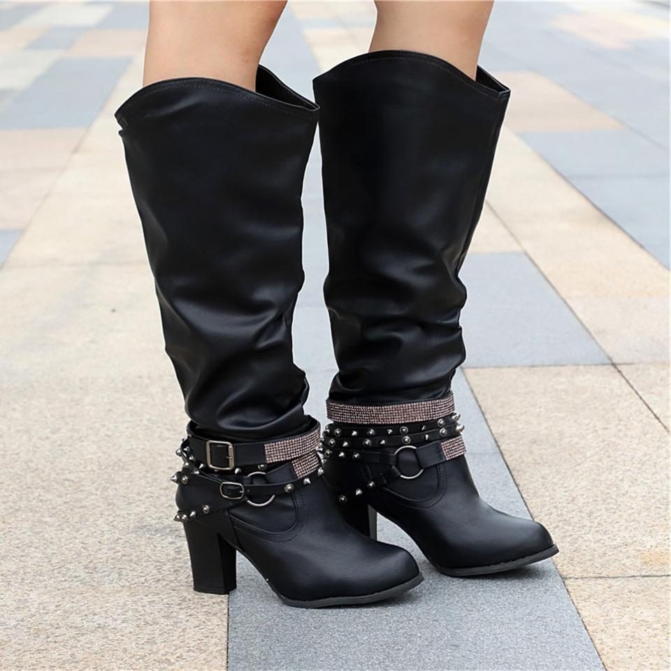 Black knee high boots featuring studded straps and a block heel, crafted from slouchy vegan leather for a stylish and comfortable fit for women. 9
