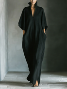 Black maxi dress featuring kimono sleeves and convenient pockets, designed for women in a comfortable oversized cotton blend. 0