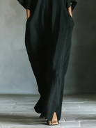 Black maxi dress featuring kimono sleeves and convenient pockets, designed for women in a comfortable oversized cotton blend. 3
