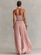 Blush jumpsuit featuring a ruched waist and wide-leg design, showcasing an elegant halter neck style perfect for formal occasions. 4