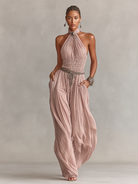 Blush jumpsuit featuring a ruched waist and wide-leg design, showcasing an elegant halter neck style perfect for formal occasions. 5