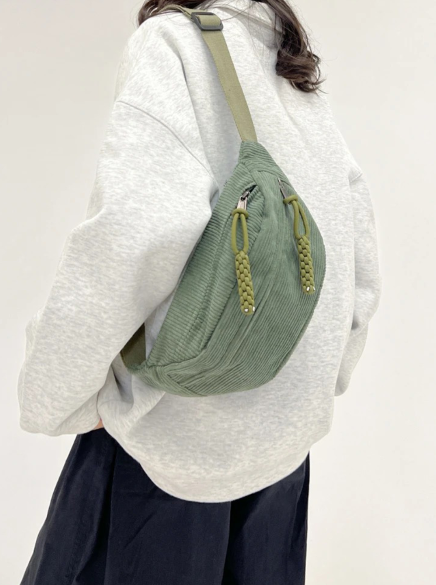 Corduroy crossbody bag in sage green featuring a crescent design and an adjustable strap, perfect for women’s casual style. 1