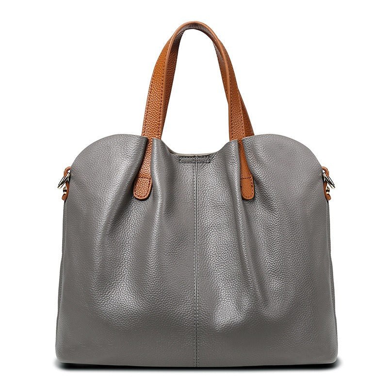 Genuine leather handbag with adjustable strap, featuring luxurious lychee grain cowhide, available in blue, black, pink, gray, and beige, designed 0