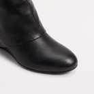 Knee high black boots for women featuring a stylish fold-over cuff and a comfortable low wedge heel, made with vegan upper materials. 2