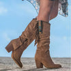 Knee high tan suede boots for women featuring fringe detail and turquoise concho, designed with a stylish block heel. 0