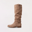 Knee high black boots for women featuring a slouch silhouette and buckled ankle tab, crafted from vegan materials with a low stacked heel. 6