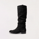 Knee high black boots for women featuring a slouch silhouette and buckled ankle tab, crafted from vegan materials with a low stacked heel. 7