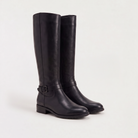 Knee high black riding boots for women with buckled ankle strap, made from faux leather and featuring a low stacked heel. 6