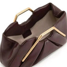 Stylish leather clutch bag featuring a gold handle, origami-inspired design, and a spacious interior made from high-quality microfiber leather. 2
