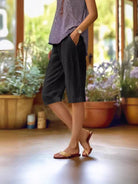 Linen capri pants featuring a V-notch waistband and convenient side pockets, designed for a relaxed fit perfect for warm days. 4