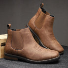 Men's tan faux-leather Chelsea boots featuring elastic side panels and stylish western stitching, perfect for a trendy and comfortable footwear choice. 0