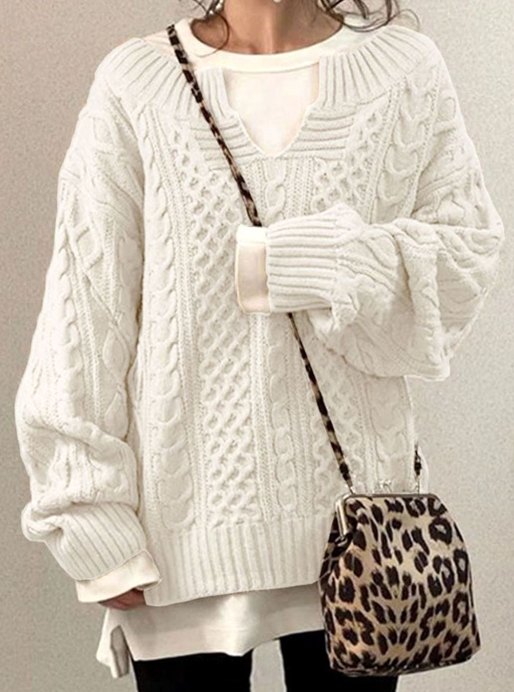 Oversized cable knit sweater with V-neck design, showcasing a cozy hand-knitted texture perfect for women's winter fashion. 0