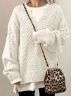 Oversized cable knit sweater with V-neck design, showcasing a cozy hand-knitted texture perfect for women's winter fashion. 0