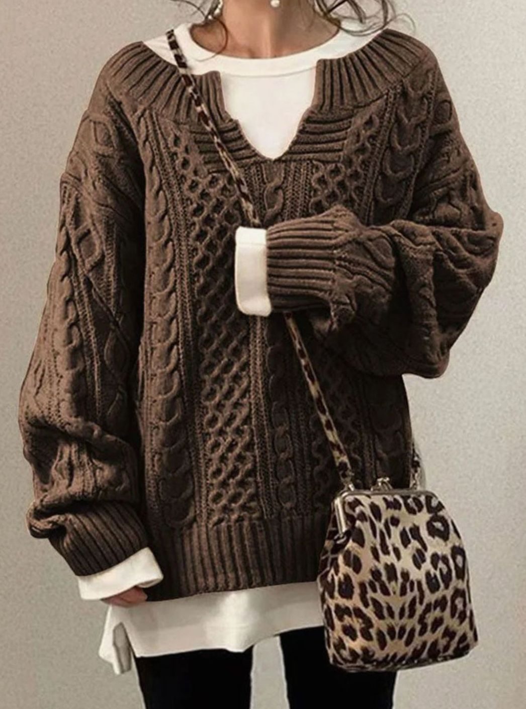 Oversized cable knit sweater with V-neck design, showcasing a cozy hand-knitted texture perfect for women's winter fashion. 2