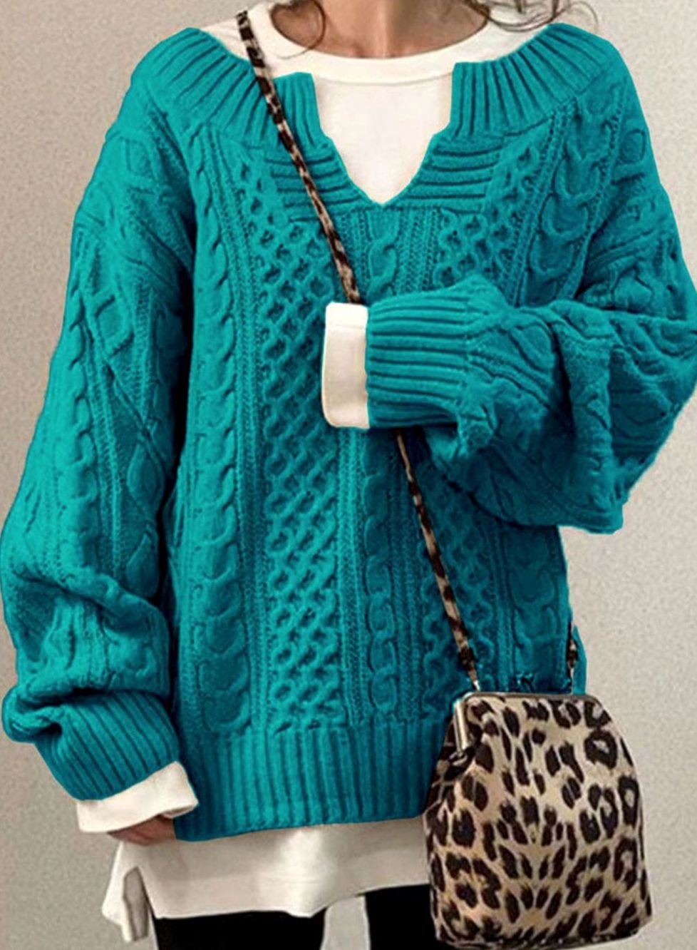 Oversized cable knit sweater with V-neck design, showcasing a cozy hand-knitted texture perfect for women's winter fashion. 6