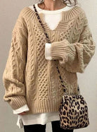 Oversized cable knit sweater with V-neck design, showcasing a cozy hand-knitted texture perfect for women's winter fashion. 7