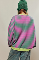 Oversized striped sweatshirt featuring neon contrast trim and drop shoulders, perfect for a stylish and comfortable casual look. 1