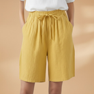 Lightweight relaxed linen shorts for women featuring an elastic waist and drawstring, perfect for summer wear. 0
