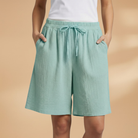 Lightweight relaxed linen shorts for women featuring an elastic waist and drawstring, perfect for summer wear. 10