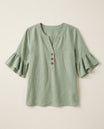 Ruffle blouse with V-neckline and decorative buttons, showcasing a feminine elegant design in soft fabric, perfect for stylish casual or formal wear. 0