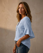 Ruffle blouse with V-neckline and decorative buttons, showcasing a feminine elegant design in soft fabric, perfect for stylish casual or formal wear. 3