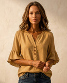 Ruffle blouse with V-neckline and decorative buttons, showcasing a feminine elegant design in soft fabric, perfect for stylish casual or formal wear. 5