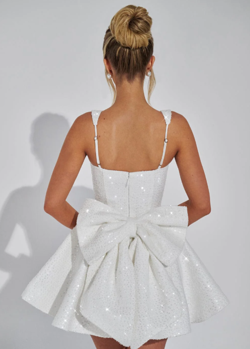 Sequin mini dress with flared skirt and back bow detail, perfect for wedding guests and cocktail parties. 8