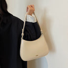 Shoulder bag with adjustable strap, featuring a minimalist curved design in vegan leather, perfect for everyday use and compact storage. 3