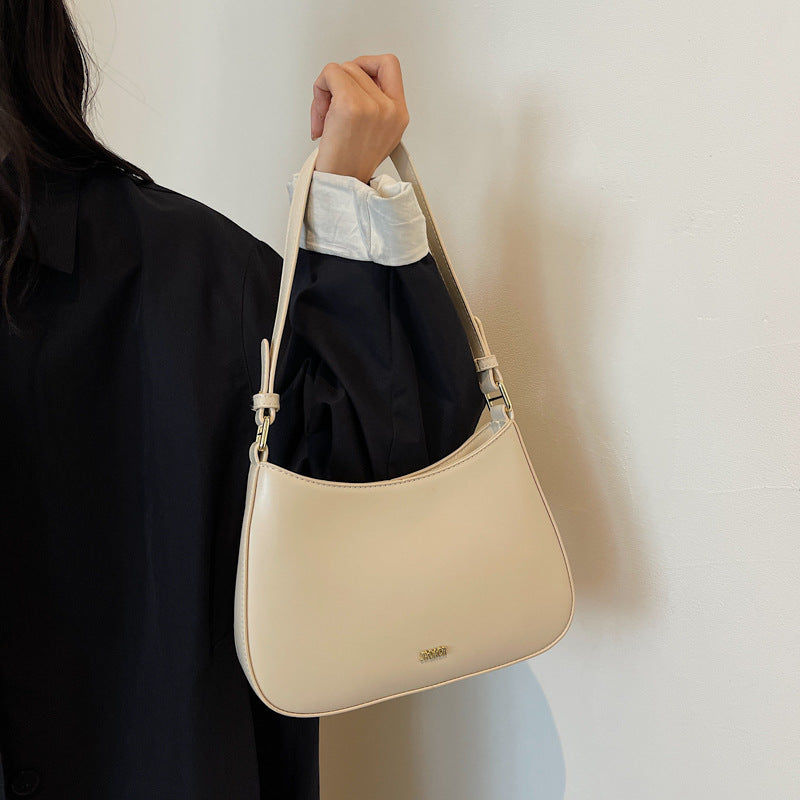 Shoulder bag with adjustable strap, featuring a minimalist curved design in vegan leather, perfect for everyday use and compact storage. 3