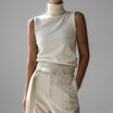 Sleeveless knit top for women featuring a soft turtleneck design and ribbed hem, perfect for layering or wearing alone. 0